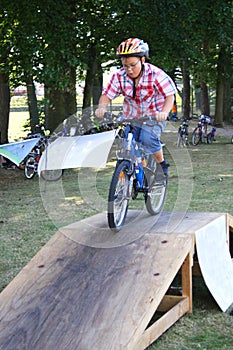 Boy rides his bike over a ramp during skill training