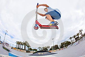 Boy rides his scooter at a skate park