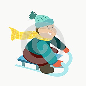 A boy rides a sled down a hill in winter
