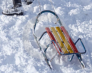 The boy rides a sled from the mountain in winter