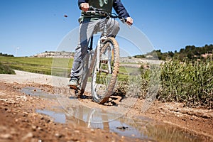 A boy is riding a bike on a muddy road