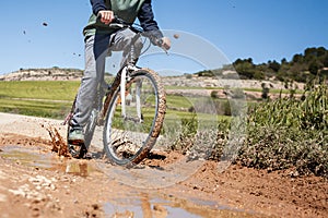 A boy is riding a bike on a muddy road