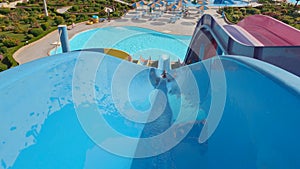 Boy Riding Down an Slide in a Water Park. Having Fun on Water Slides Aqua Park Glides. Water Park Aquapark Sliders With Pool on a