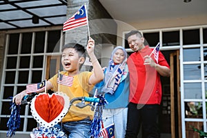 Boy riding his bicycle full with malaysia flag