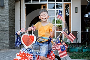 Boy riding his bicycle full with malaysia flag