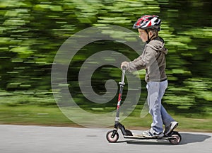 Boy riding his scooter