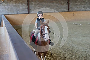 Boy riding horse back. Equestrian sport. Animals and children. Dressage. Sport equipment. Farm.