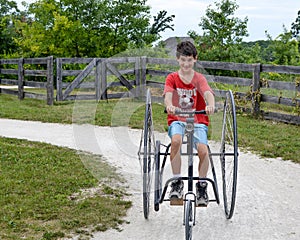 Boy Riding Old Fashioned Three Wheeled Bicycle