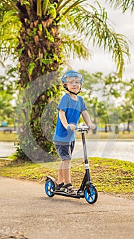 Boy riding scooters, outdoor in the park, summertime. Kids are happy playing outdoors VERTICAL FORMAT for Instagram