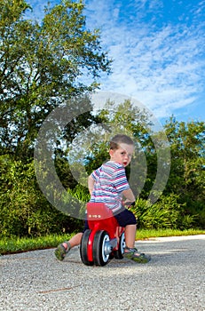 Boy riding on a toy motorbike