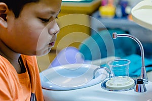 Boy rinse one`s mouth after dentist common operation of cleaning