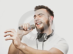 Boy Rocking Out. Image of a handsome bearded man singing to the microphone.