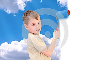 Boy with roller draws sky with clouds