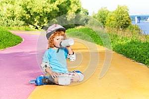 Boy rollerblading and drink water from bottle