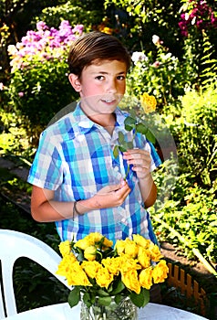 boy with roses on blossoming garden background