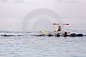 Boy rowing in sea kayak