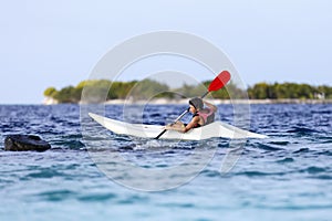 Boy rowing in sea kayak