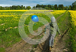 Boy running across the field with a balloon