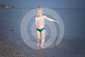 Boy running along the water on the beach