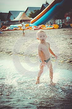 Boy running along the water on the beach