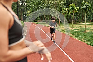 Boy running with blurred foreground of sportswoman