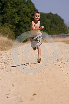 Boy running on dusty road