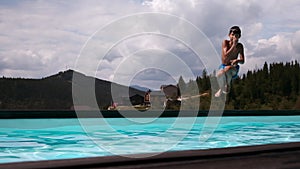 Boy running and jumping into swimming pool at resort