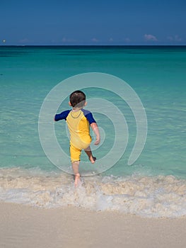 Boy running into ocean