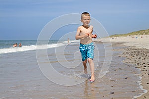 Boy running and smiling at beach