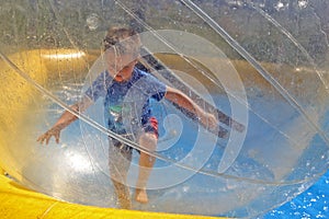 Boy running in water sphere
