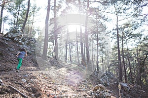 A boy runs along a mountain path