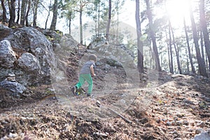 A boy runs along a mountain path