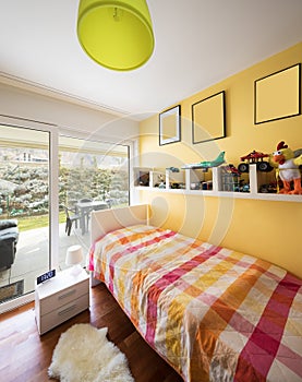 Boy`s bedroom with a shelf full of toys