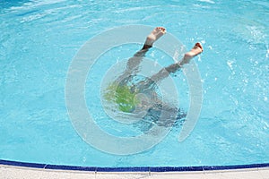 Boy& x27;s dive in motion, legs in air; symbolizing carefree summers and the joy of swimming