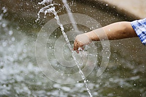 Boy's fatty hand playing with water photo