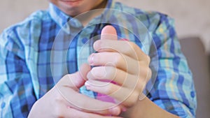 Boy`s hands knead and squeeze a pink slime. Boy plays with slime.