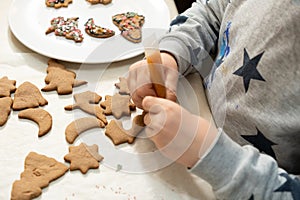 The boy& x27;s hands make Christmas cookies. The little cook.