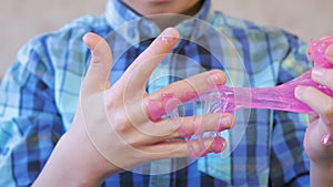 Boy`s hands with a pink slime. Boy plays with slime.
