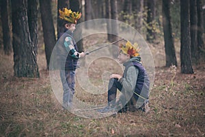 The boy's portrait with a crown on the head and a sword in hands. The thoughtful boy dreams.