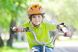 The boy in a safety helmet rides a bicycle