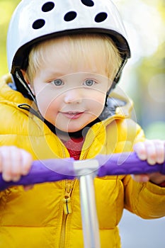 Boy in safety helmet to ride scooter