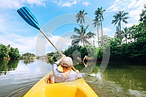 Boy sailing in canoe boat on tropical lagoon