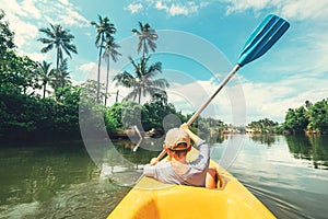 Boy sailing in canoe boat on tropical lagoon