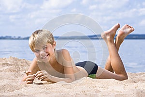 Boy in sand on seashore photo