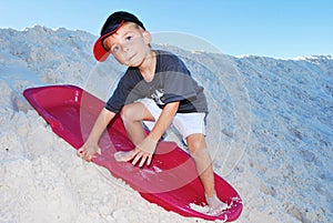 Boy sand sledding