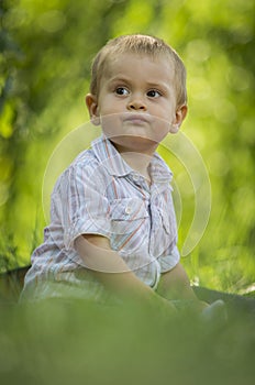 Boy sat in green park