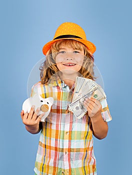 Boy saving money in a piggybank. Child boy with american dollars money. Business, saving and economic.