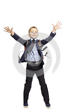 Boy in a school uniform with a backpack in a jump, isolated on white background