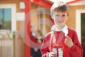 Boy In School Uniform Eating Potato Chip In Playground