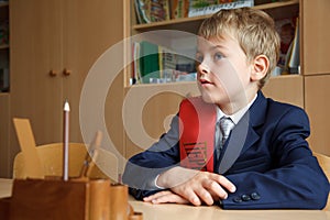 Boy in school uniform at his desk.